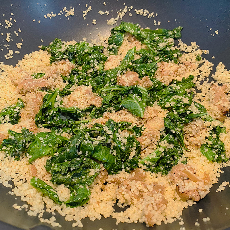 Añade el cuscús y la carne vegetal SoMeat a la kale y mézclalo todo.