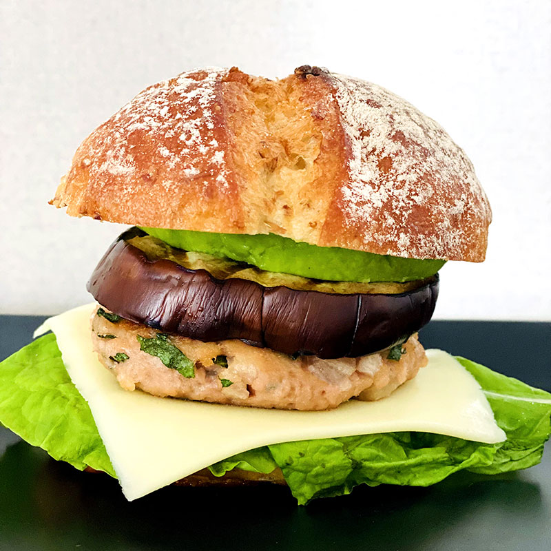 Spread Dijon mustard on the bun and add lettuce, cheese, Iburi-gakko and Shiso cutlet, eggplant, avocado slice.