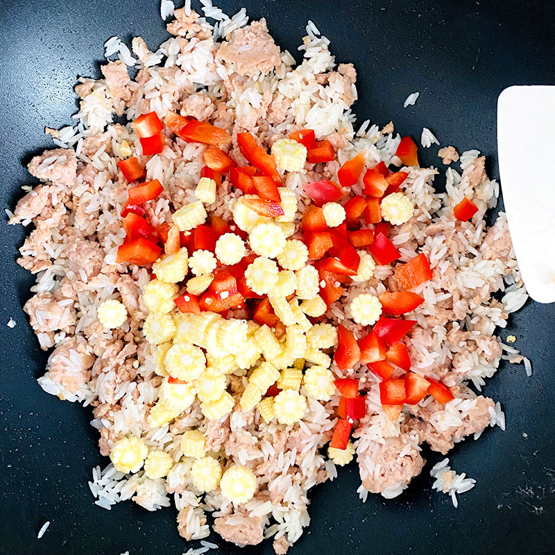 Añade el picado de maíz y pimiento al arroz con carne SoMeat y saltea hasta que la carne quede dorada. Luego apaga el fuego.