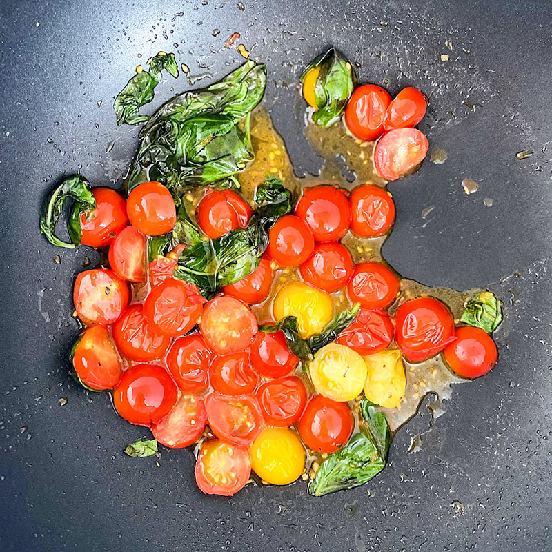 Cuando el aceite esté caliente, añade los tomates y un poco de albahaca fresca a la sartén. Saltea durante 3 minutos y sazona a tu gusto.