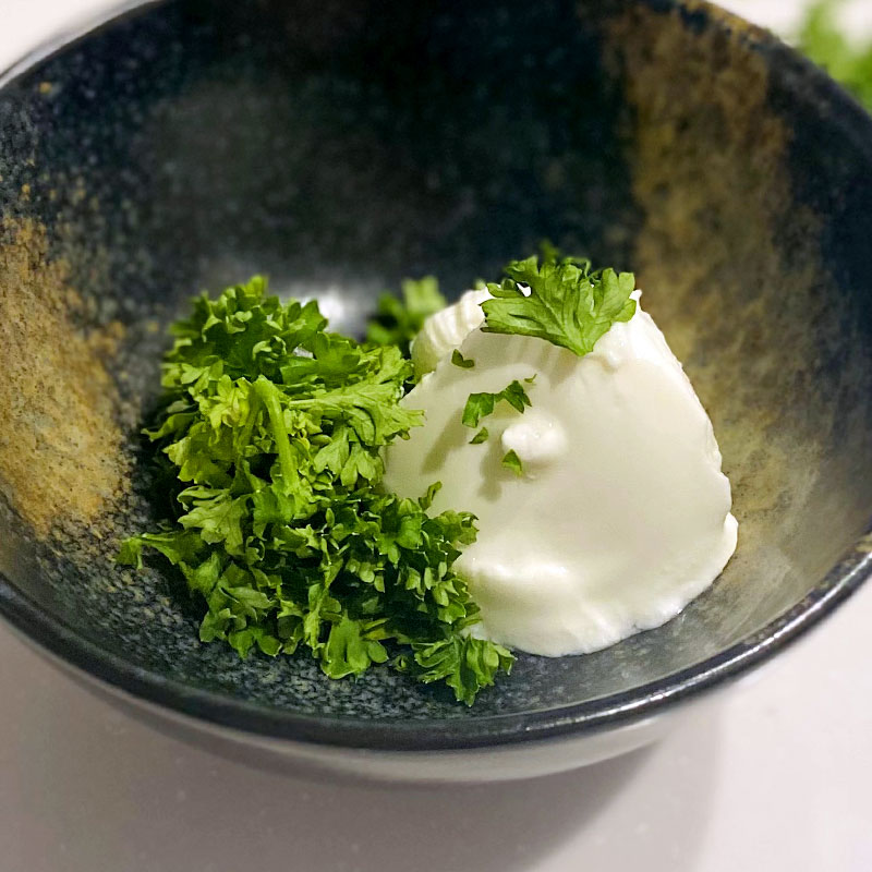 Vierte el yogur de soja en un bol pequeño y añade el perejil. Mezcla y sazona a tu gusto.