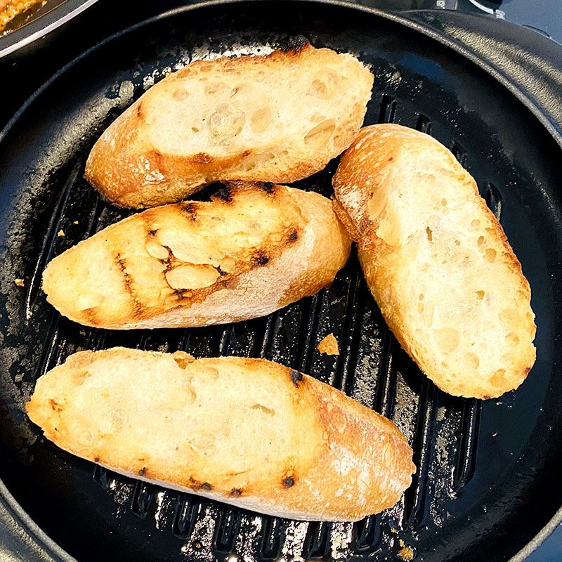 Pour a little bit of olive oil on the baguette and then grill them or warm up in an oven.