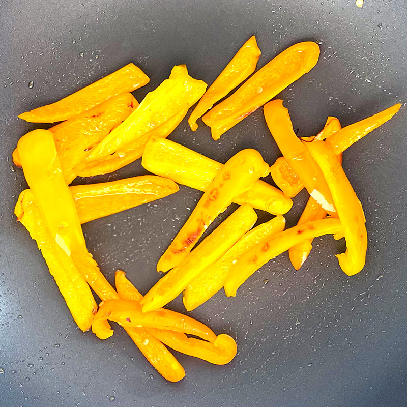 Cut the bell peppers into thin slices and fry them over a medium heat for about 2 min.