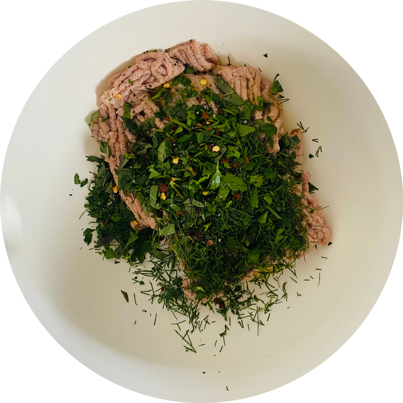En un bol, mezcla la carne picada vegetal de SoMeat con las hierbas bien picadas, el pimiento rojo en polvo y un poco de aceite de oliva.